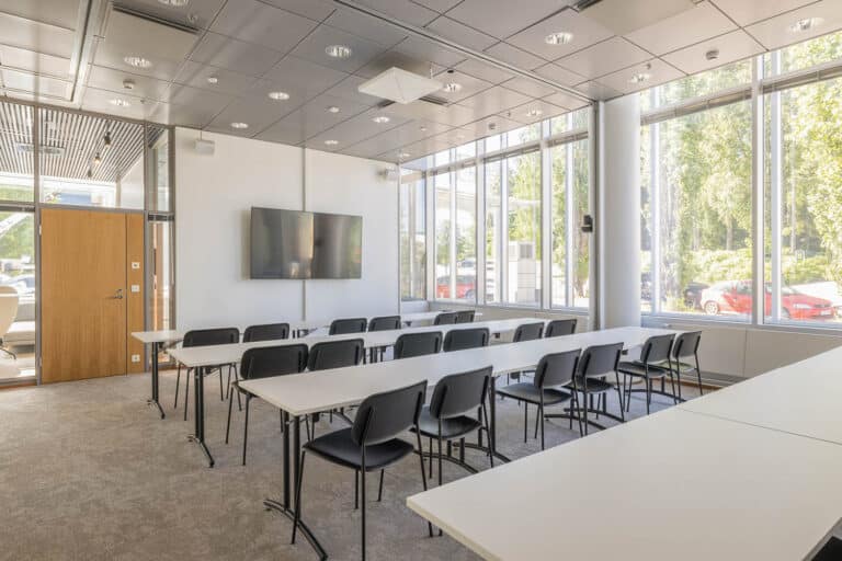 Koulutustila, jossa on suuret ikkunat ja korkea katto.