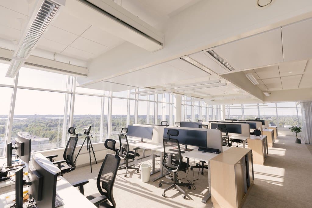 Valoisa ja vaaleilla väreillä sisustettu avotoimisto upeilla näkymillä