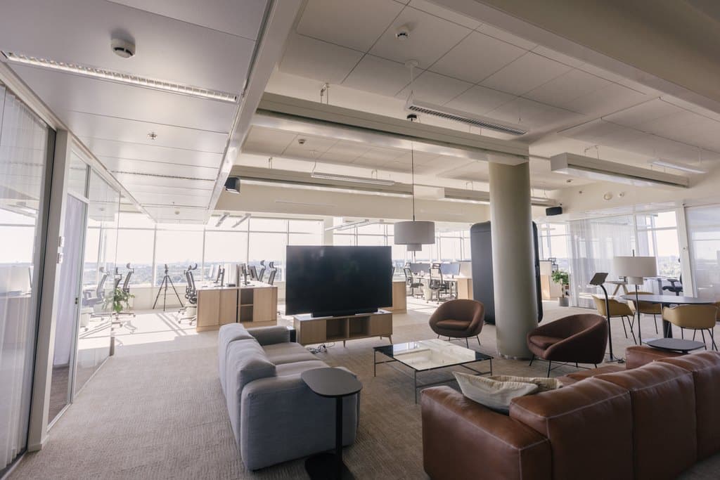 Valoisa avotoimistotila jossa sohvilla kalustettu lounge-alue